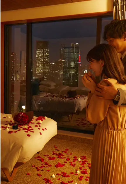 ベッドの上の赤バラ花束に感動する彼女