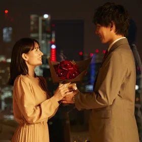 彼からバラの花束を受け取る彼女
