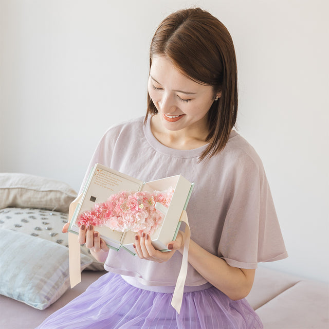 満開の桜が本の中に咲き誇る、春の訪れのようなロマンチックプロポーズギフト「ブックサクラ」。2羽の蝶が彩る桜のアーチに、フェイクの指輪を忍ばせた特別な演出。