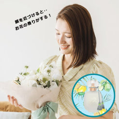 香りで思い出を彩る、ホワイトダズンフラワー。彼女が笑顔で見つめる花束からふんわり広がる優しい香りが、心に残る特別なひとときを演出。