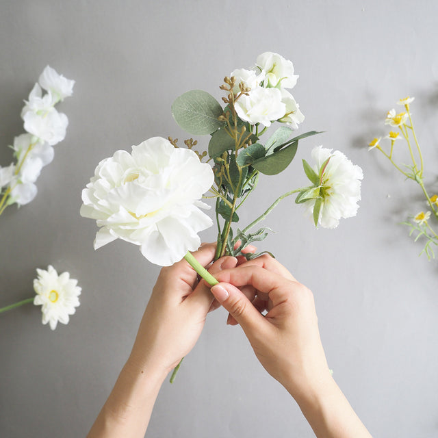 12種類の花を1本ずつ丁寧に束ねた、ホワイトダズンフラワーの制作風景。人気の高い白やグリーンの草花を中心に、誓いの花言葉を込めた特別なブーケ。プロポーズや記念日など、大切な日に贈る枯れない花束ギフト。