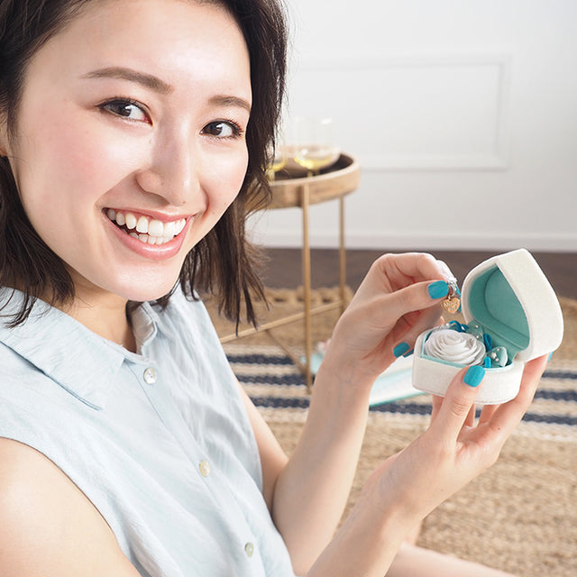 指輪が無くても箱パカプロポーズを叶えるハート型のプロポーズボックスの夏限定デザイン。中心のフェイクダイヤを引き抜くとMarryme？（結婚してください）のメッセージ付きチャームが登場し、それを見て喜ぶ彼女。