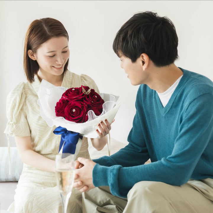 サプライズで真っ赤なバラの花束を受け取る女性。生花のようにバラの香りがするサプライズ演出が、アートフラワーは可能。