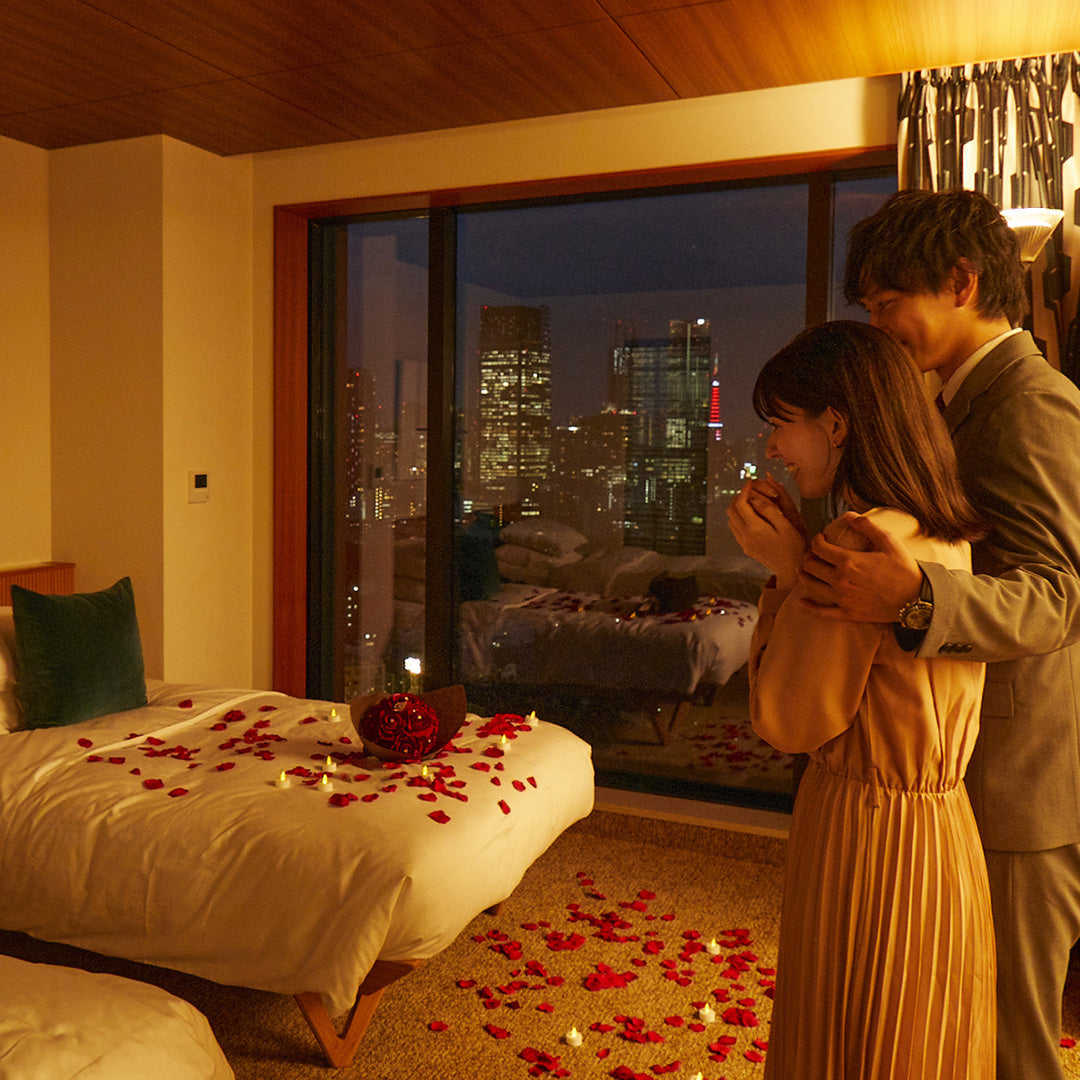 部屋に入ると花びらとキャンドルの華やかな世界が広がり、中心にはバラの花束が・・！