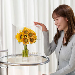 ひまわりの花束を飾る透明花瓶。中にはクラッシュアイスとマジカルウォーターがたっぷり入っており、こぼれずお手入れ不要。涼しげで夏のギフトにぴったりなインテリアフラワー。